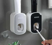 Automatic toothpaste dispenser and toothbrush holder mounted on wall for convenient and organized bathroom setup.