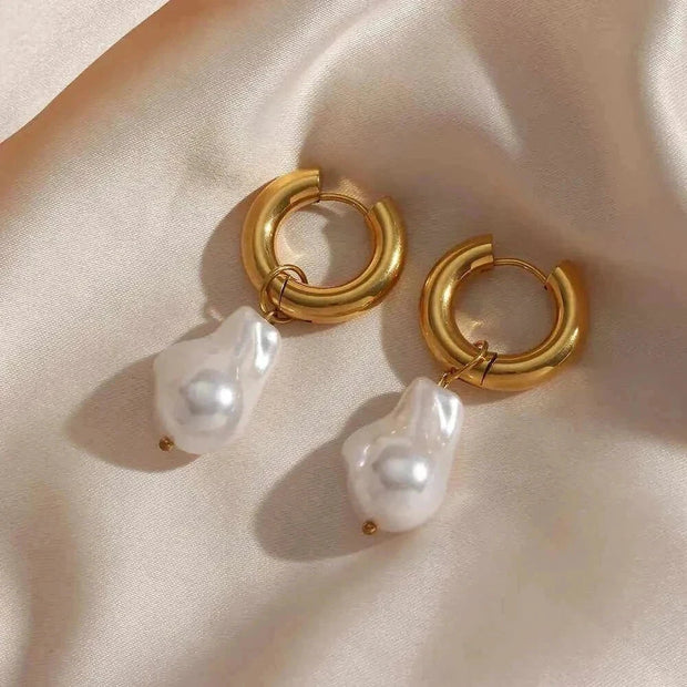 Elegant water drop earrings on satin fabric background.