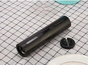 Automatic Wine Bottle Opener with sleek design and foil cutter, on a checkered tablecloth.