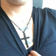 Cross Necklace with black pendant on person, symbolizing faith and style.