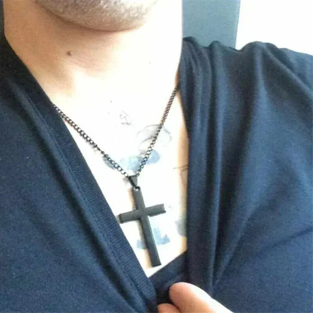 Cross Necklace with black pendant on person, symbolizing faith and style.