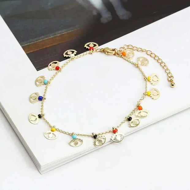 Elegant charm bracelet with colorful beads and gold chain on a book.