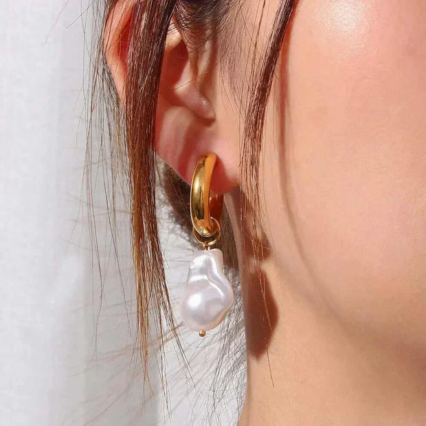Elegant Water Drop Earrings with gold finish worn on ear.