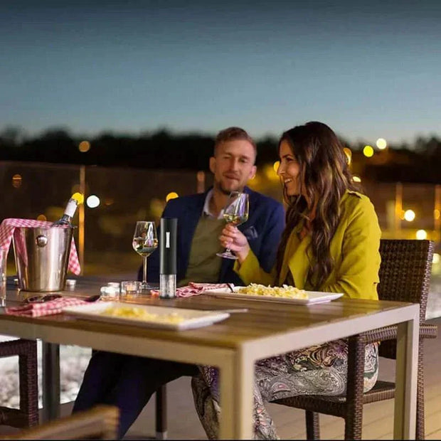 Couple enjoying wine on patio with automatic wine bottle opener.