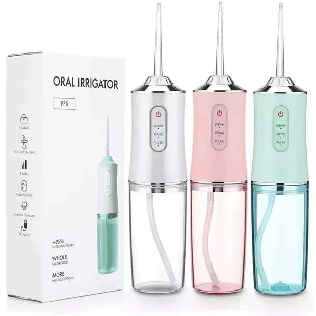Waterproof irrigator dental cleaner in white, pink, and green with interchangeable nozzles, shown next to packaging.